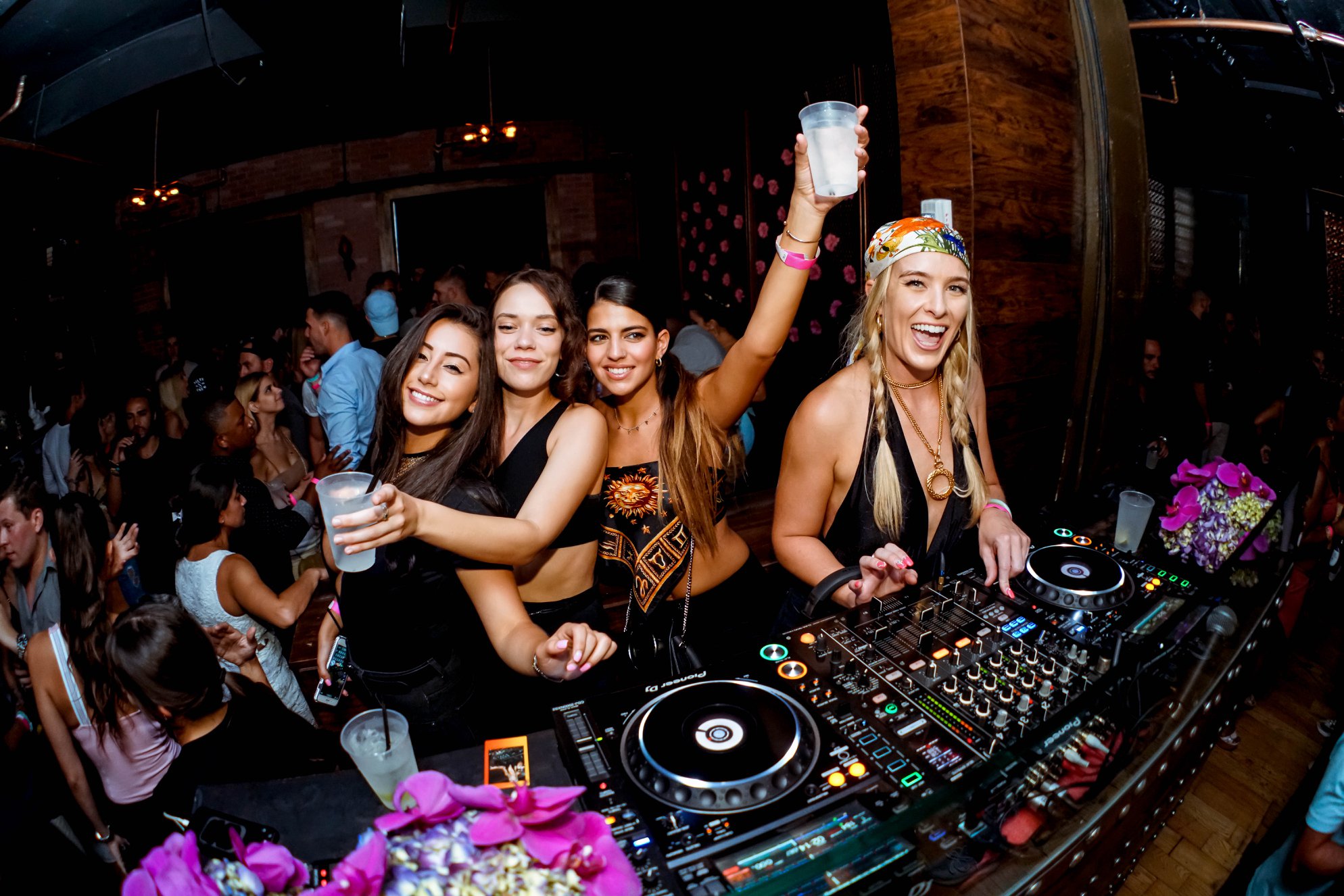 Fisheye of the dancefloor with orchid arrangements on the booth