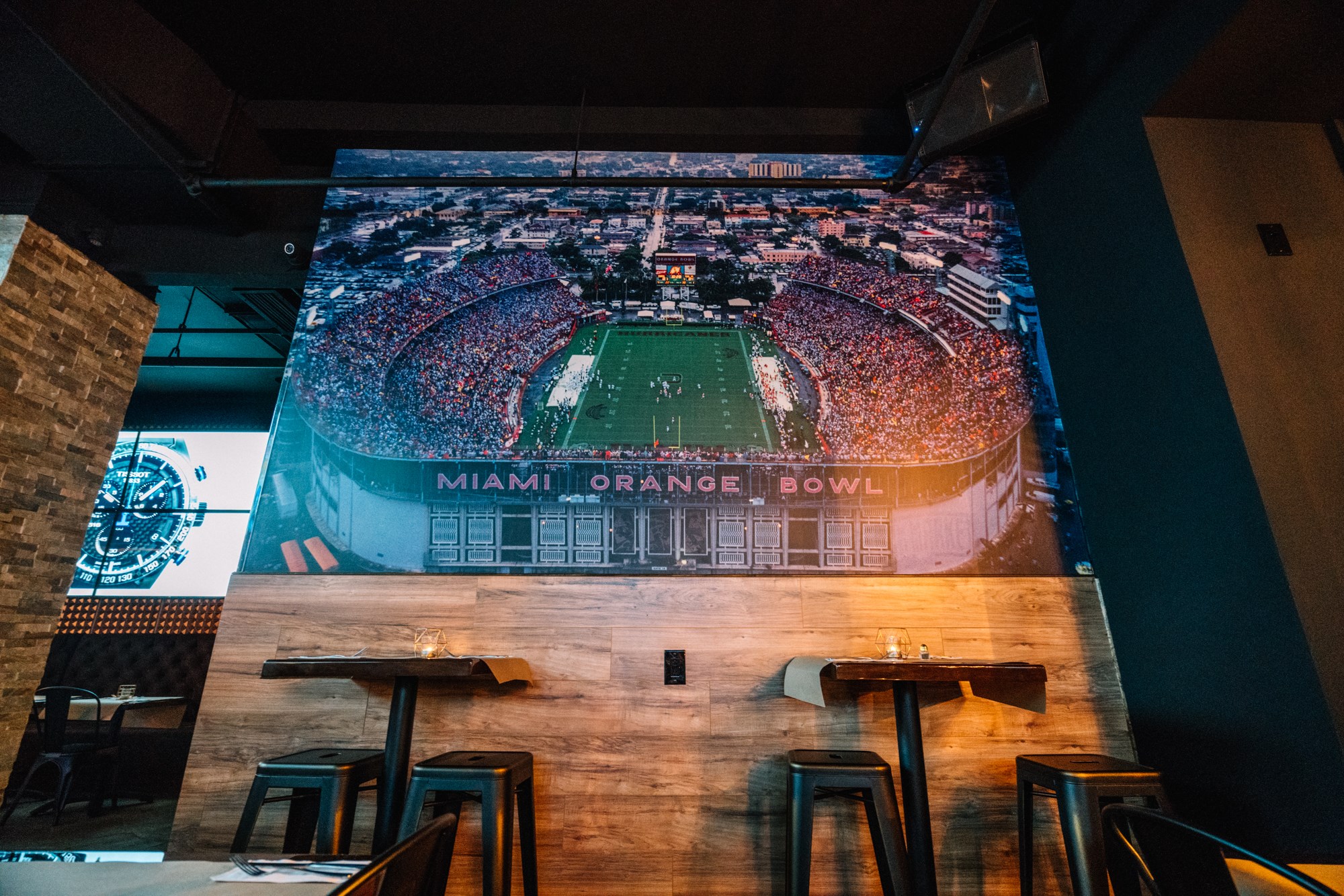 Floor-to-ceiling Miami Orange Bowl mural over the dining room