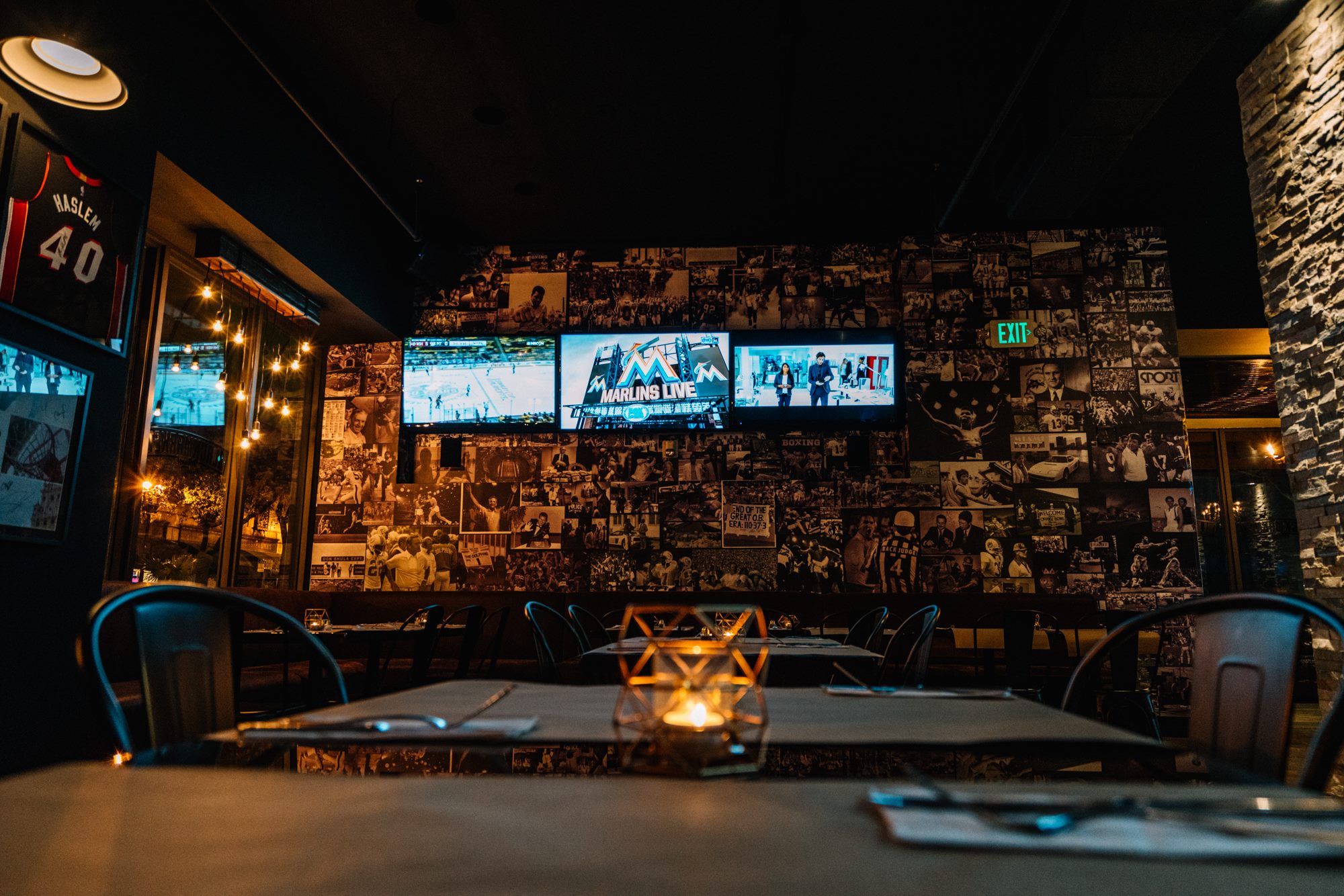 Candlelit tables along the photo-collage wall, Marlins Live on screen