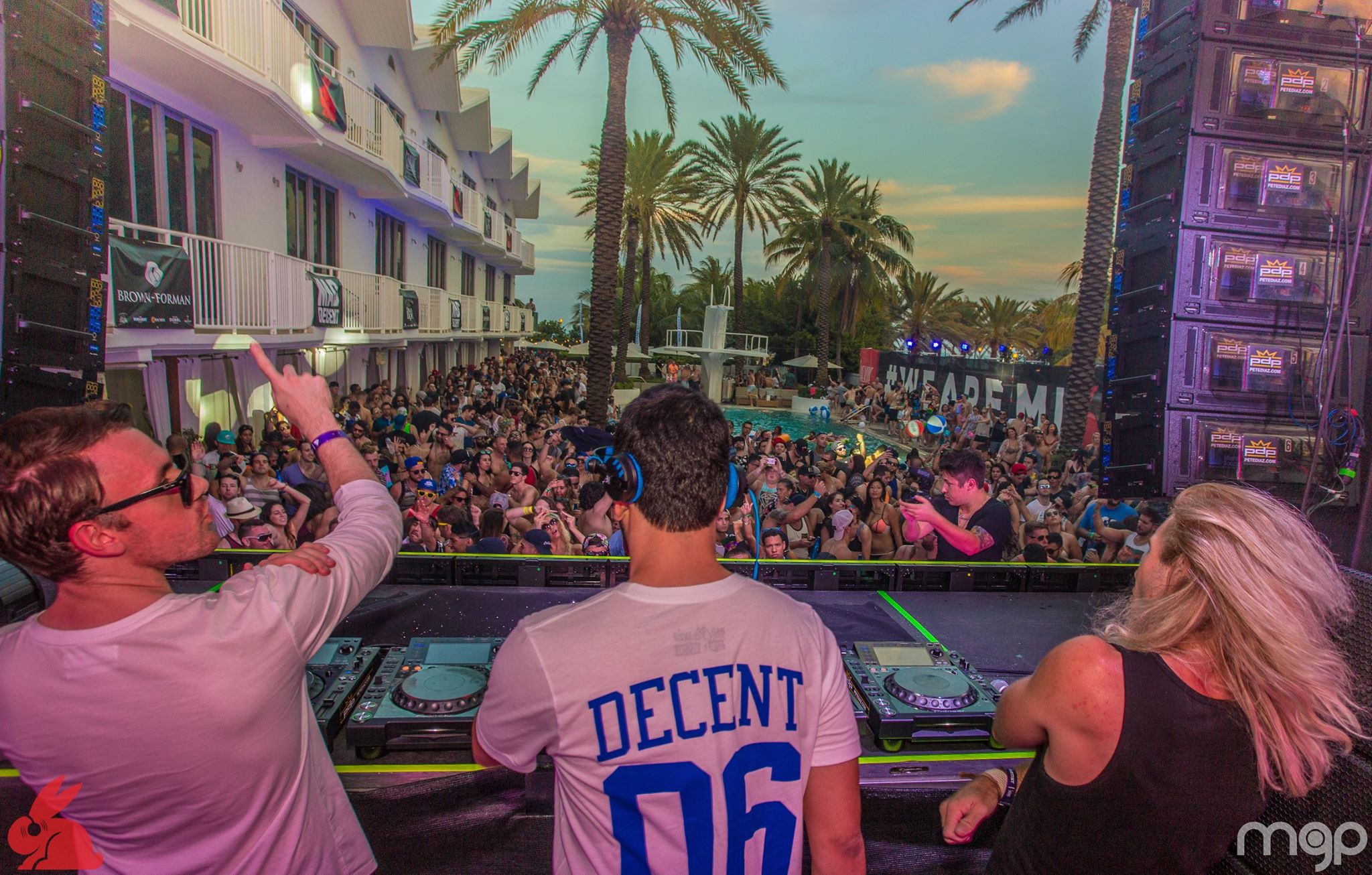 DJ duo playing back to back under colorful LED panels at night