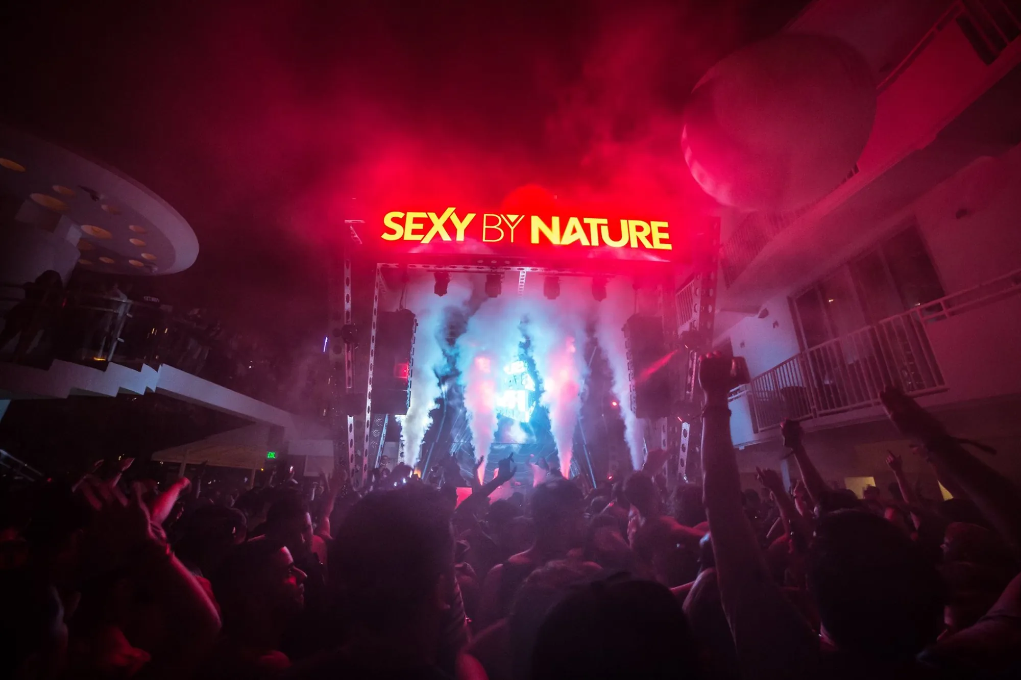 Stage and crowd under colored light at a Red Rabbit night party