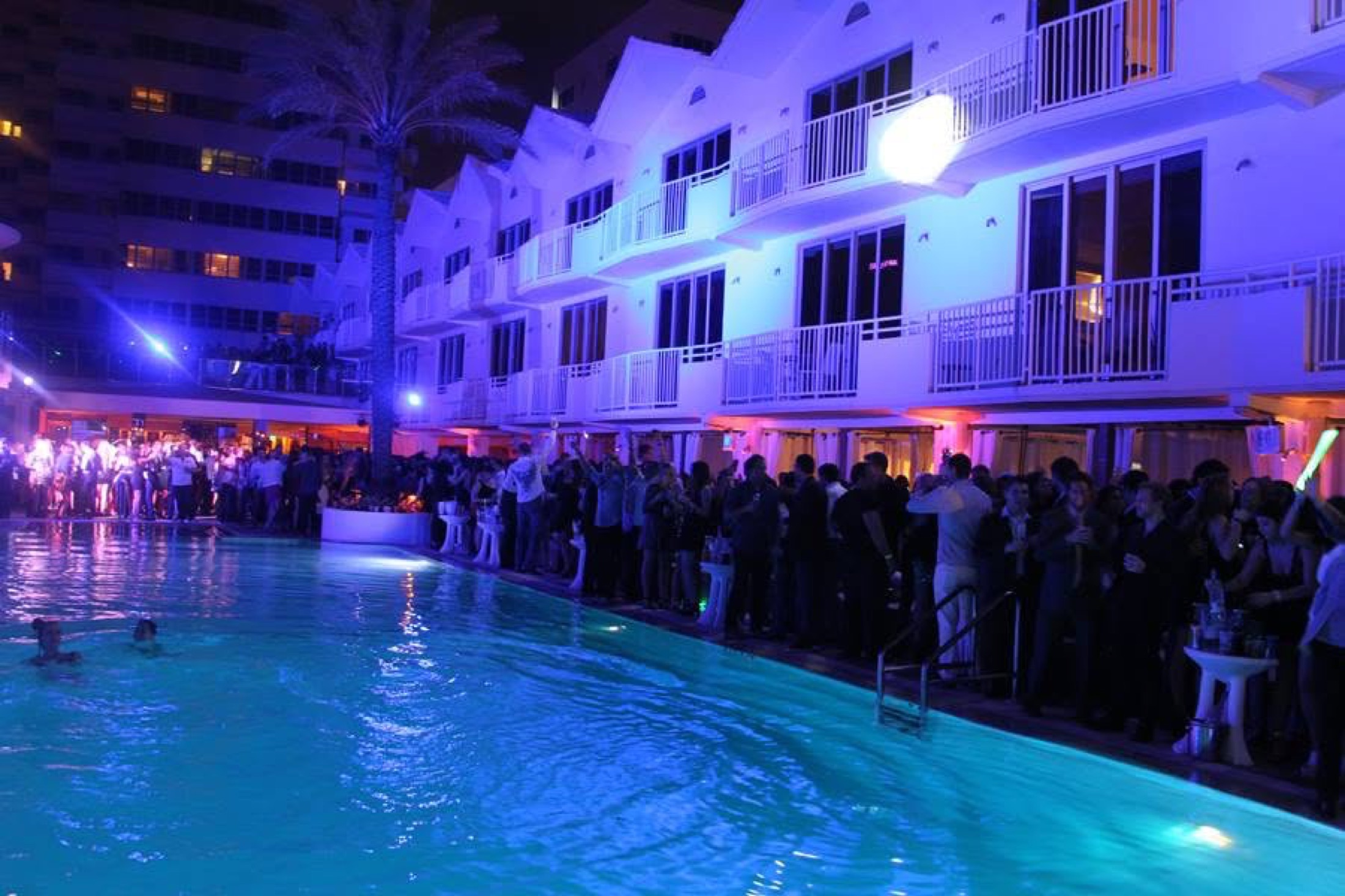 Midnight swimmers in the glowing pool as the party lines the deck