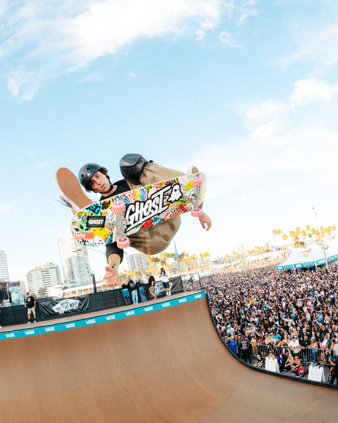Skateboarder catching air off the Vans vert ramp above a packed Long Beach crowd